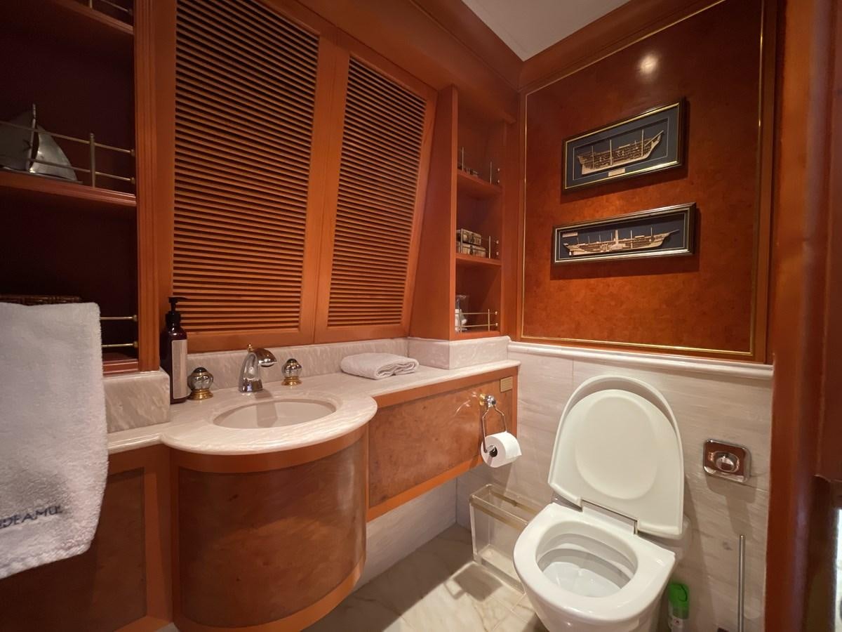 a bathroom with a toilet sink and a window aboard GAUDEAMUS Yacht for Sale