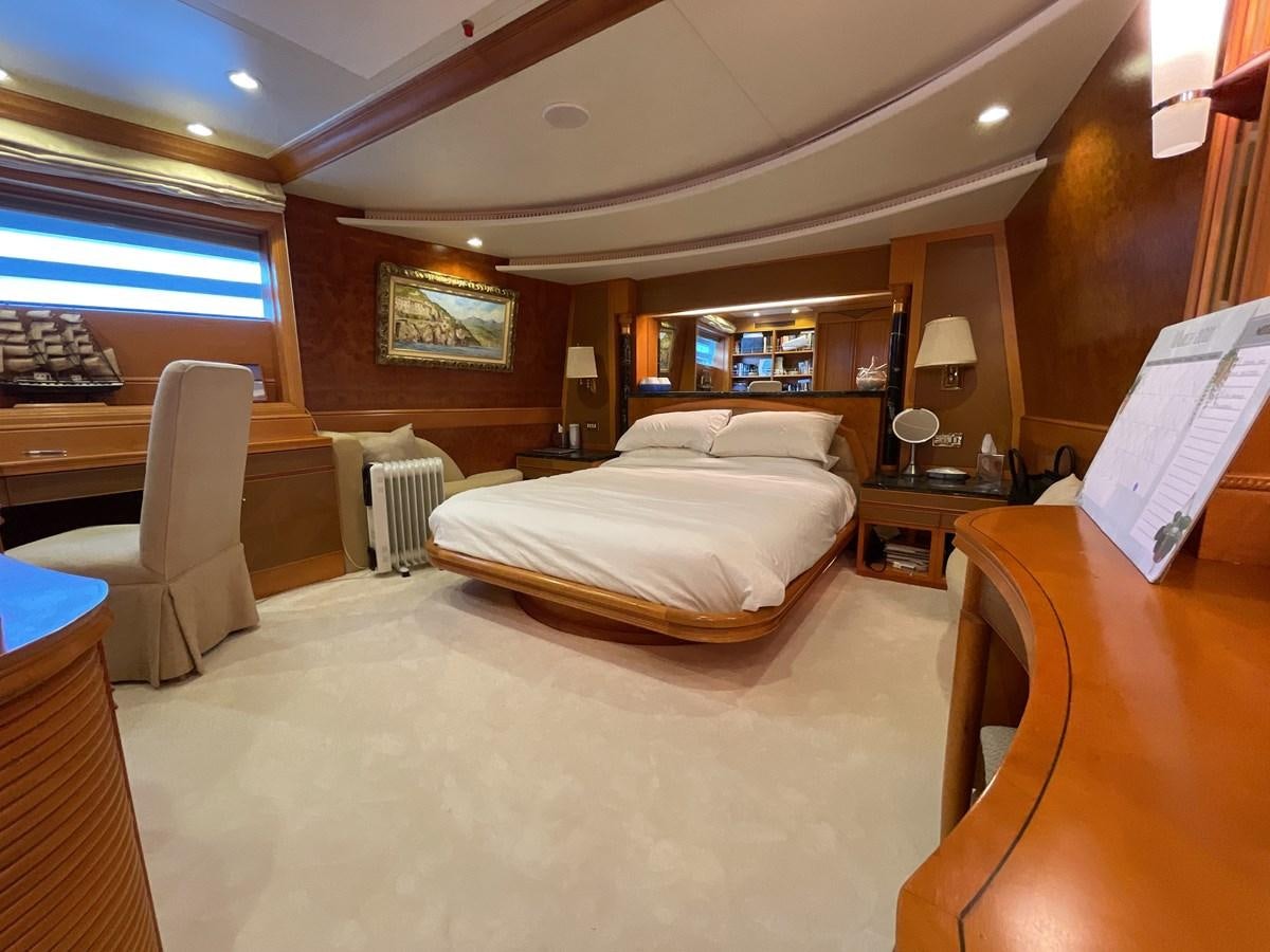 a bedroom with a bed and a bookcase aboard GAUDEAMUS Yacht for Sale