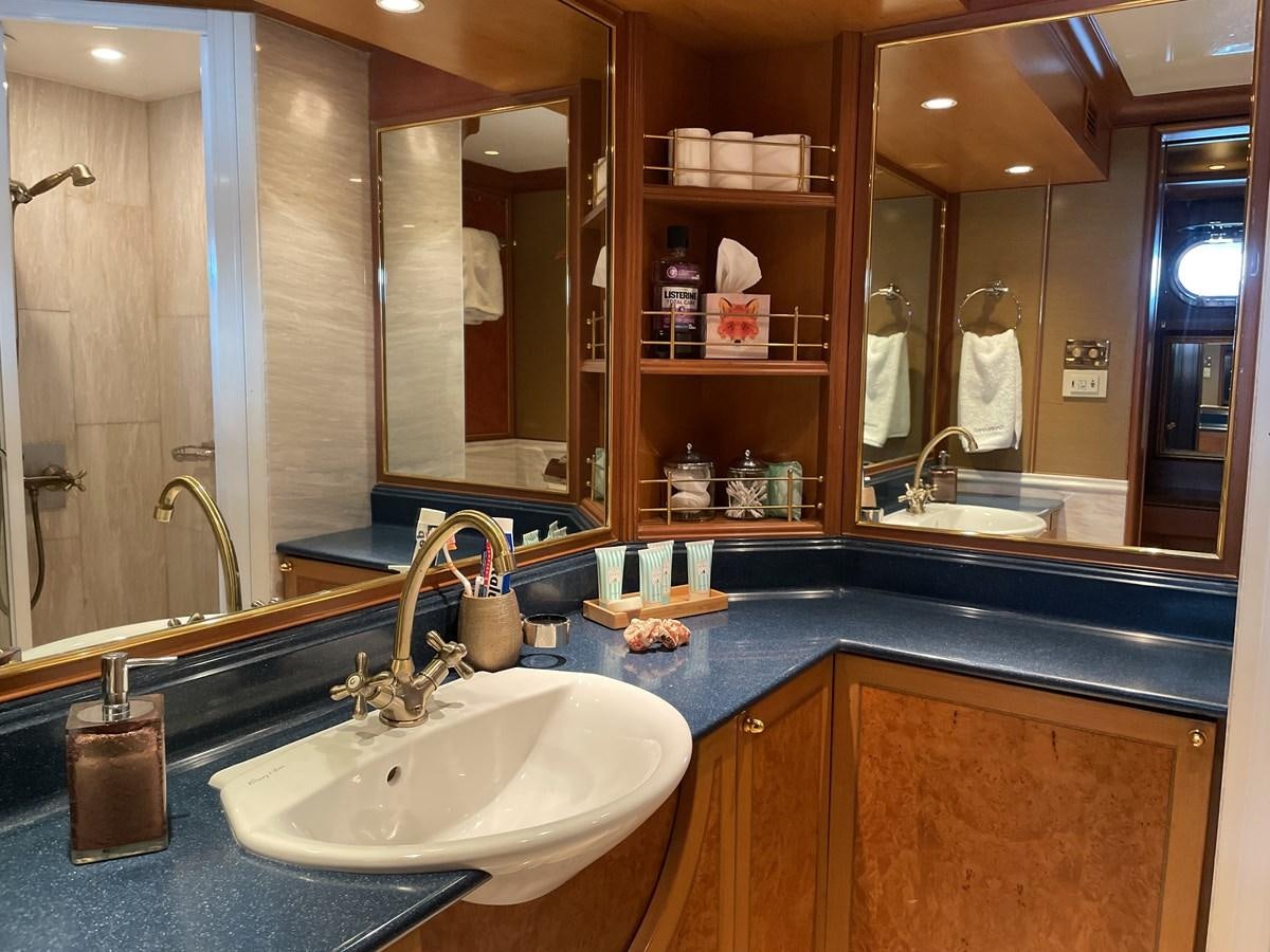 a bathroom with a countertop sink and mirror aboard GAUDEAMUS Yacht for Sale