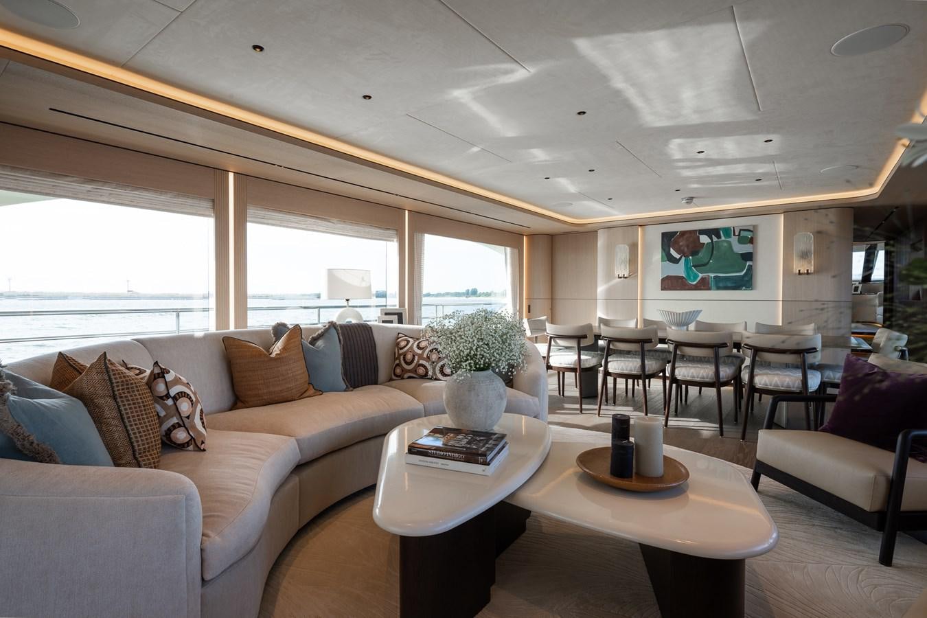 a living room with a couch and a table aboard MOONEN 110 MUSTIQUE Yacht for Sale
