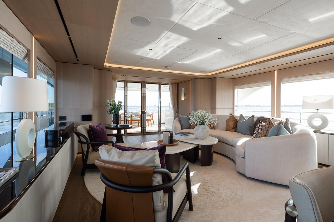 a living room with a couch and a table aboard MOONEN 110 MUSTIQUE Yacht for Sale