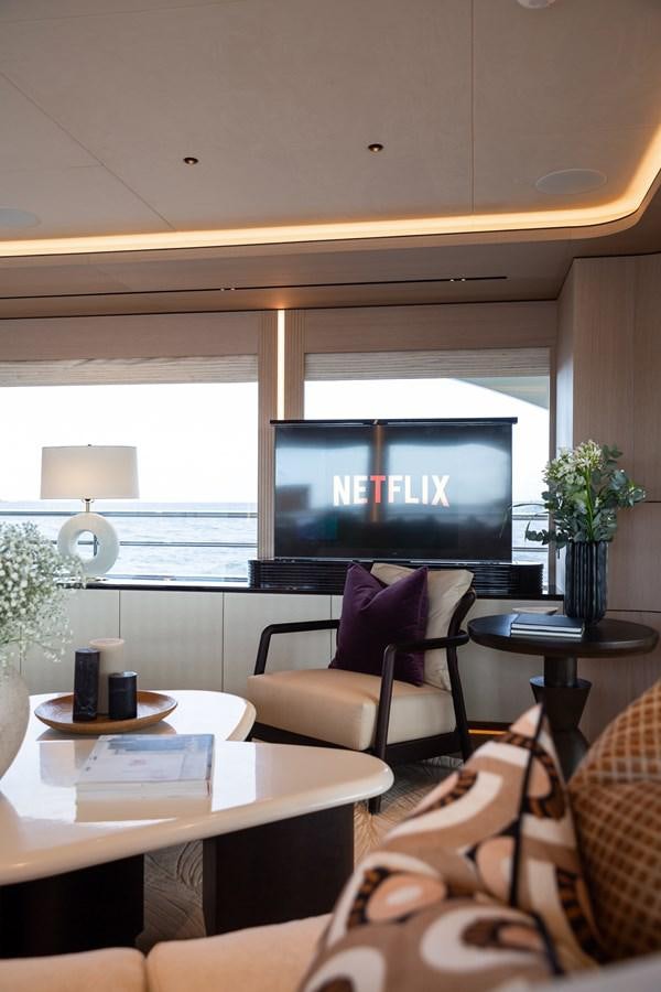 a room with a tv and chairs aboard MOONEN 110 MUSTIQUE Yacht for Sale