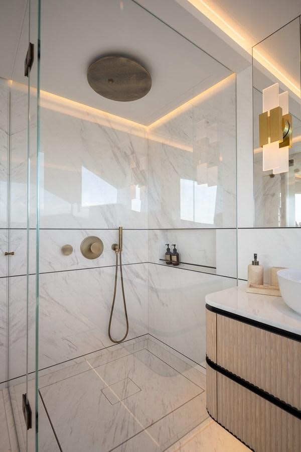 a bathroom with a glass shower aboard MOONEN 110 MUSTIQUE Yacht for Sale