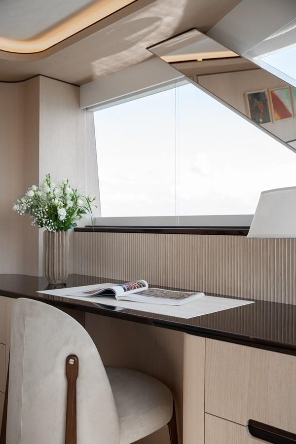 a desk with a vase of flowers aboard MOONEN 110 MUSTIQUE Yacht for Sale