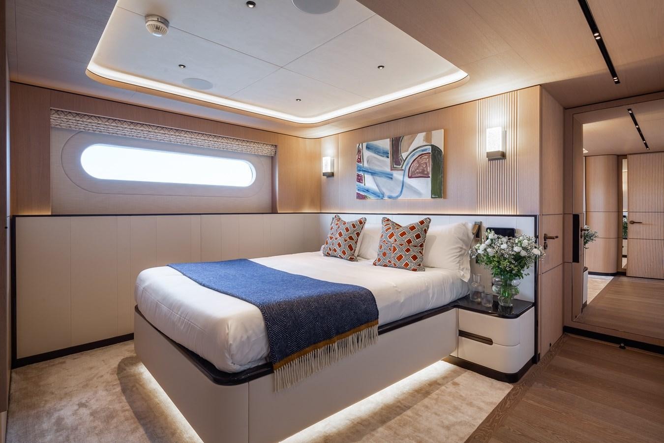 a bedroom with a bed and a window aboard MOONEN 110 MUSTIQUE Yacht for Sale