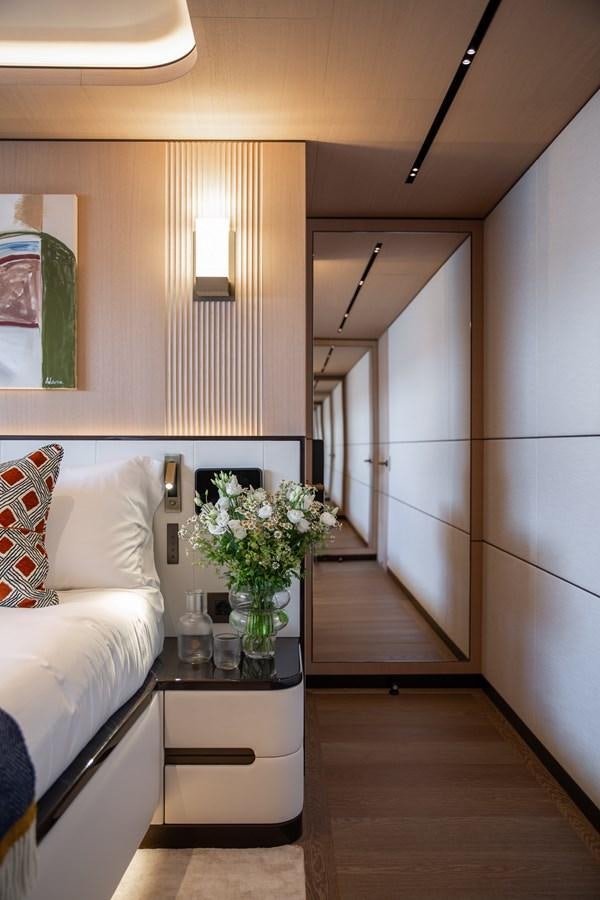 a living room with a white couch and a vase of flowers aboard MOONEN 110 MUSTIQUE Yacht for Sale