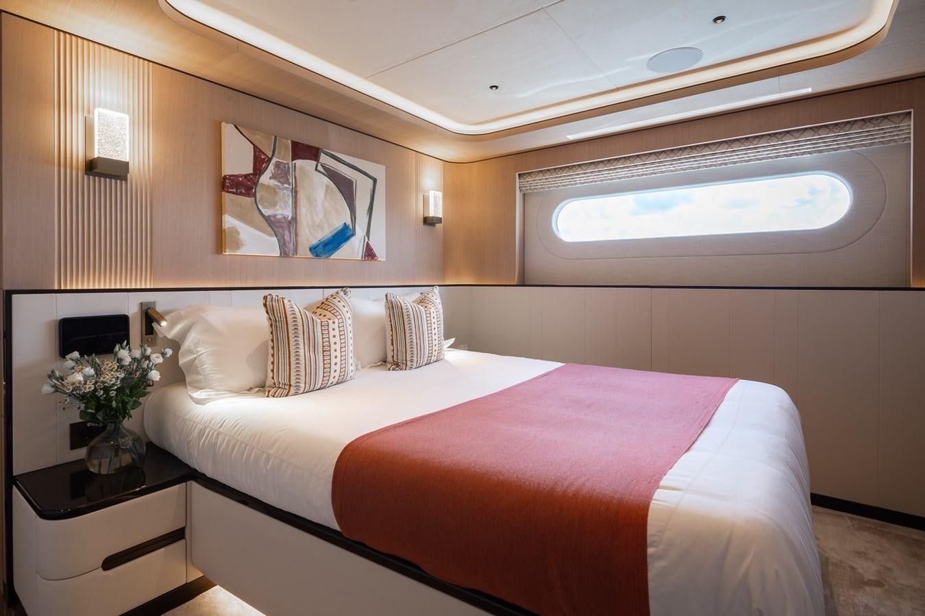a bed with a pink bed spread aboard MOONEN 110 MUSTIQUE Yacht for Sale