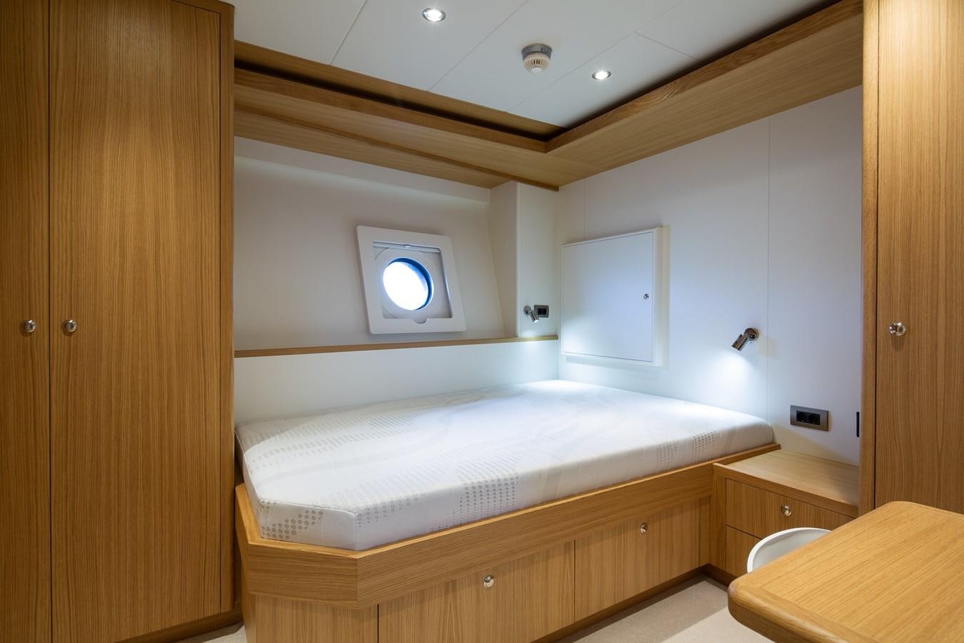 a room with a bed and a window aboard MOONEN 110 MUSTIQUE Yacht for Sale