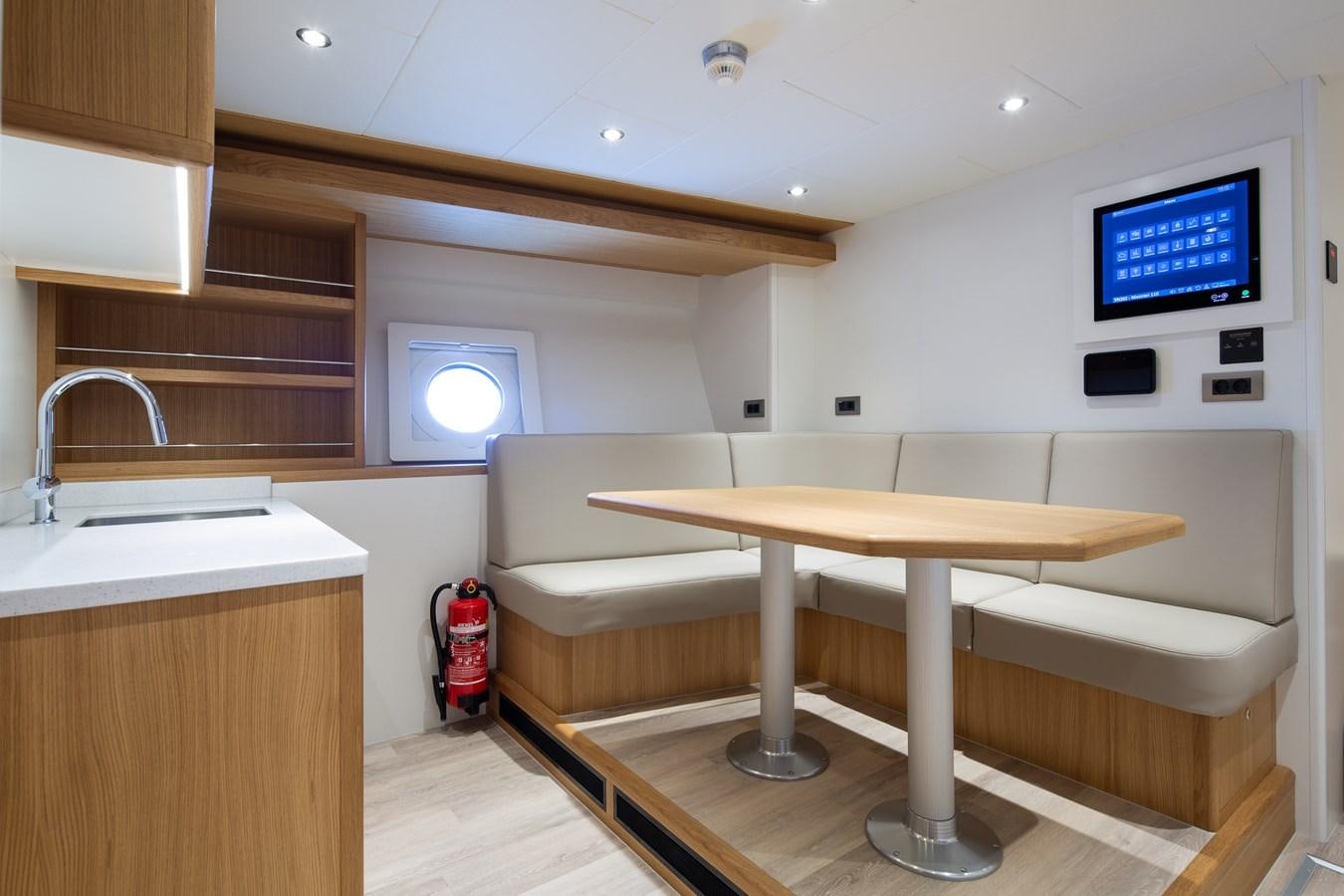 a room with a couch and a table aboard MOONEN 110 MUSTIQUE Yacht for Sale