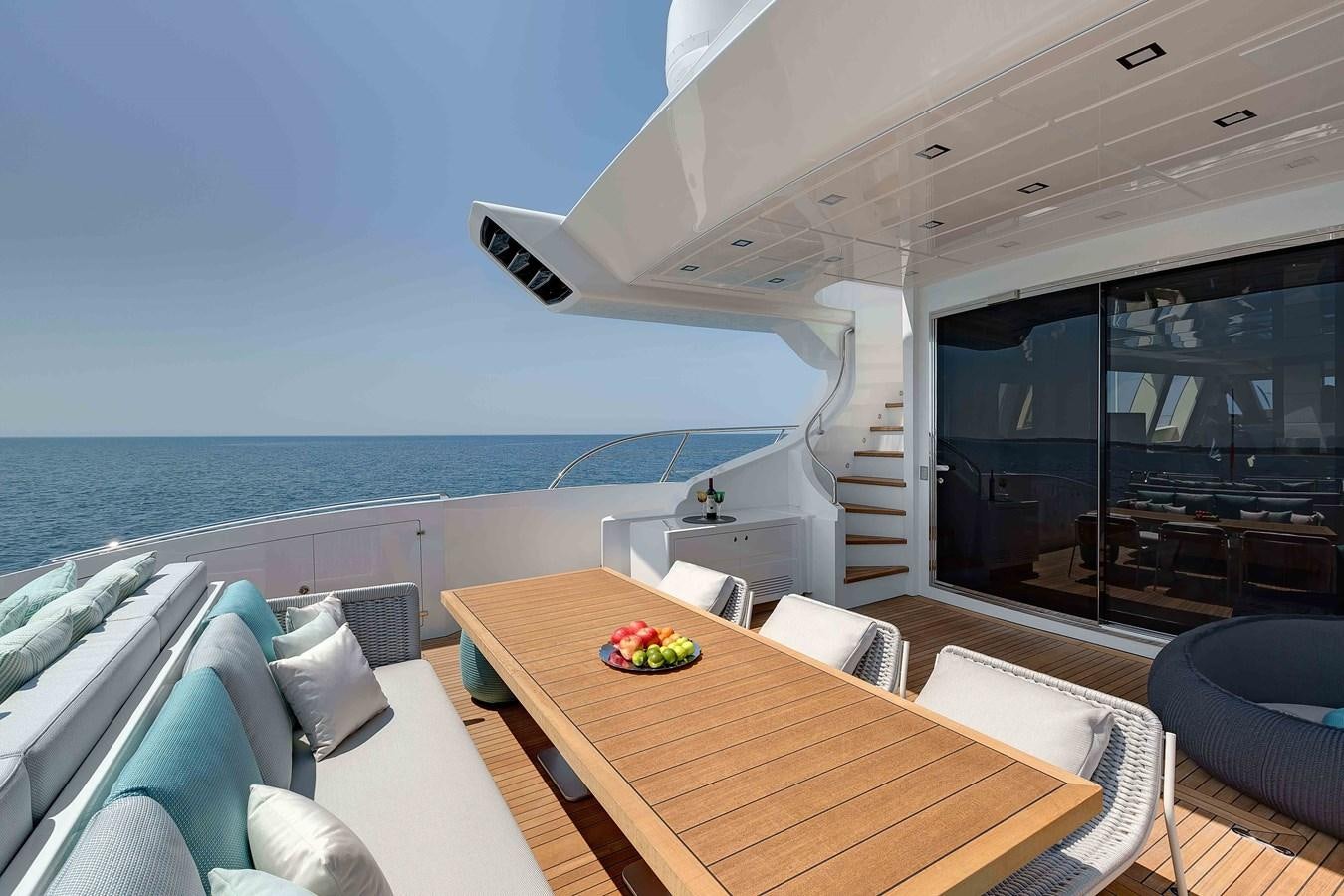 a large open space with a table and chairs and a large body of water aboard MANGUSTA 110 - CAREFULLY USED Yacht for Sale