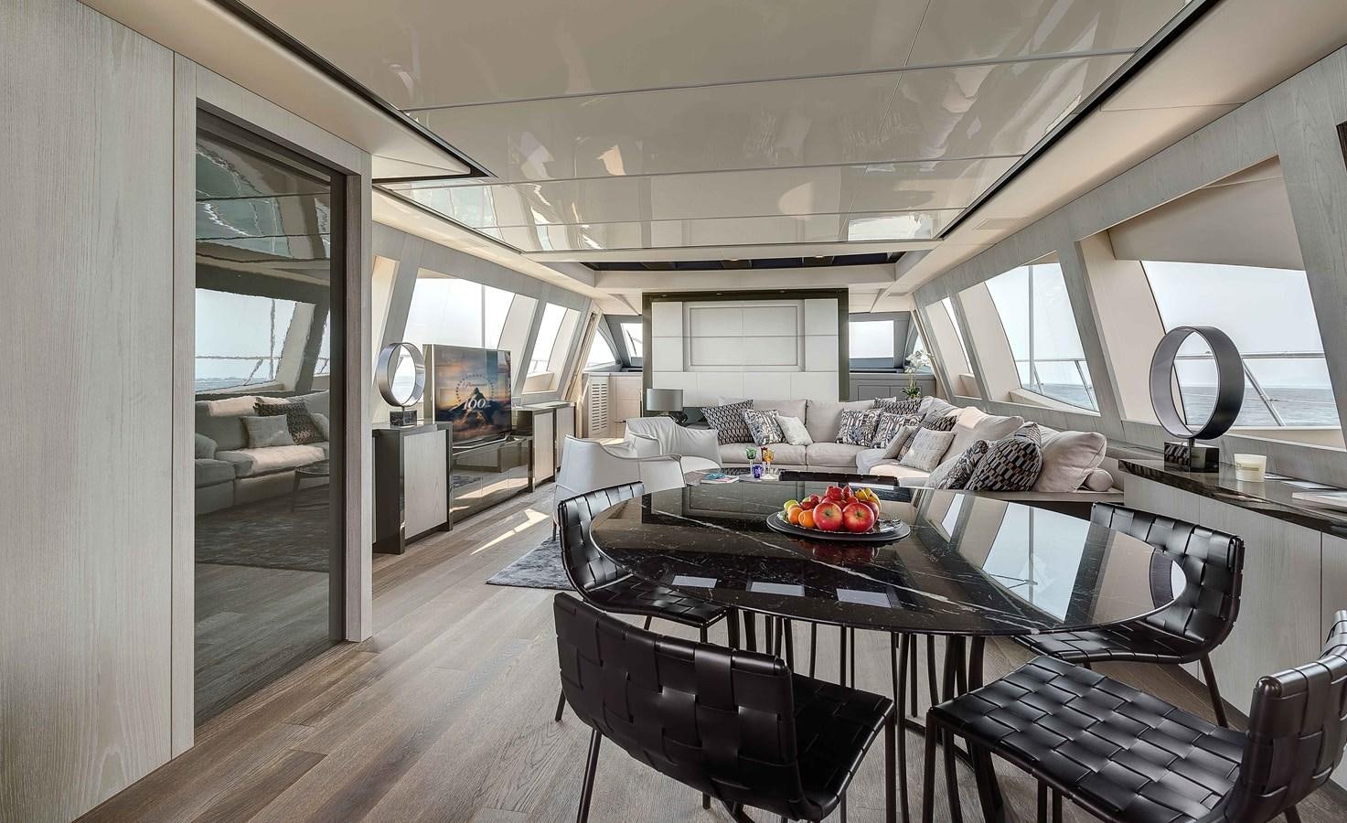 a room with a table and chairs aboard MANGUSTA 110 - CAREFULLY USED Yacht for Sale