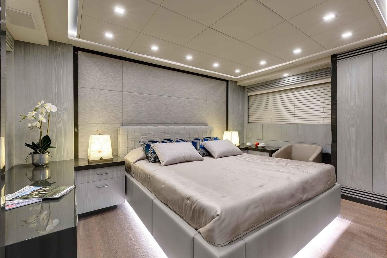 a bedroom with a bed and a chair aboard MANGUSTA 110 - CAREFULLY USED Yacht for Sale