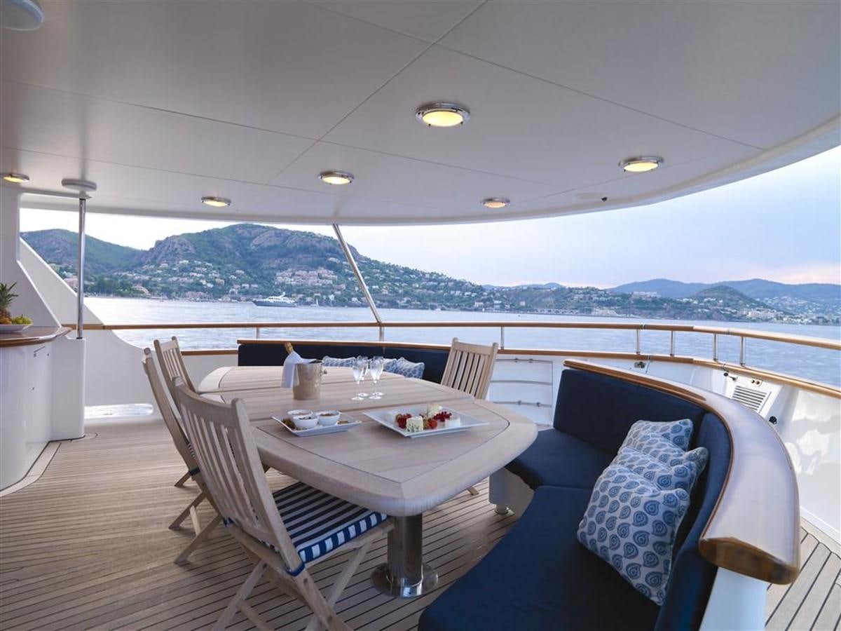 a table and chairs on a deck aboard DONA AMELIA II Yacht for Sale