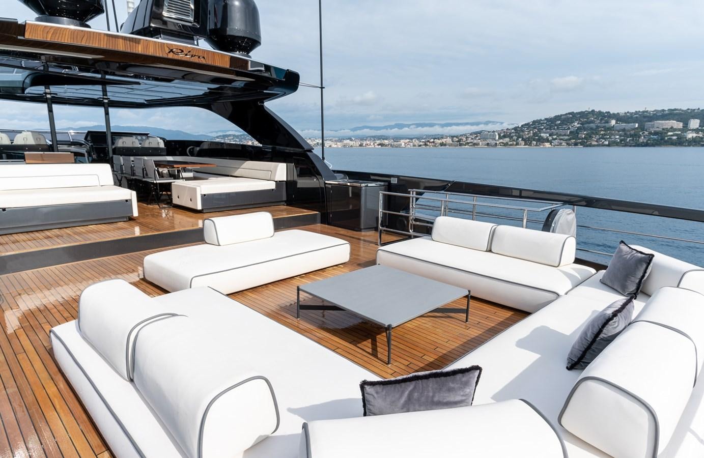 a room with a couch and a table and a large window aboard RIVA DOLCEVITA 110 Yacht for Sale