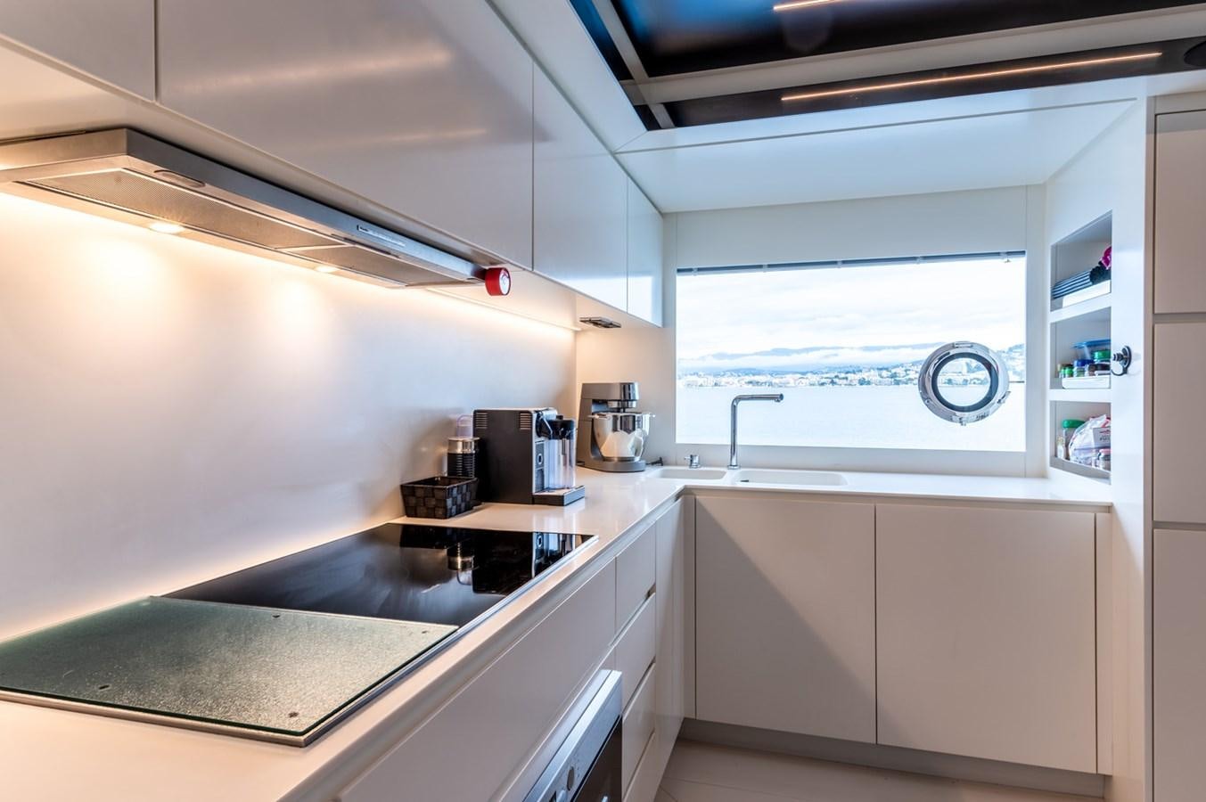 a kitchen with white cabinets aboard RIVA DOLCEVITA 110 Yacht for Sale