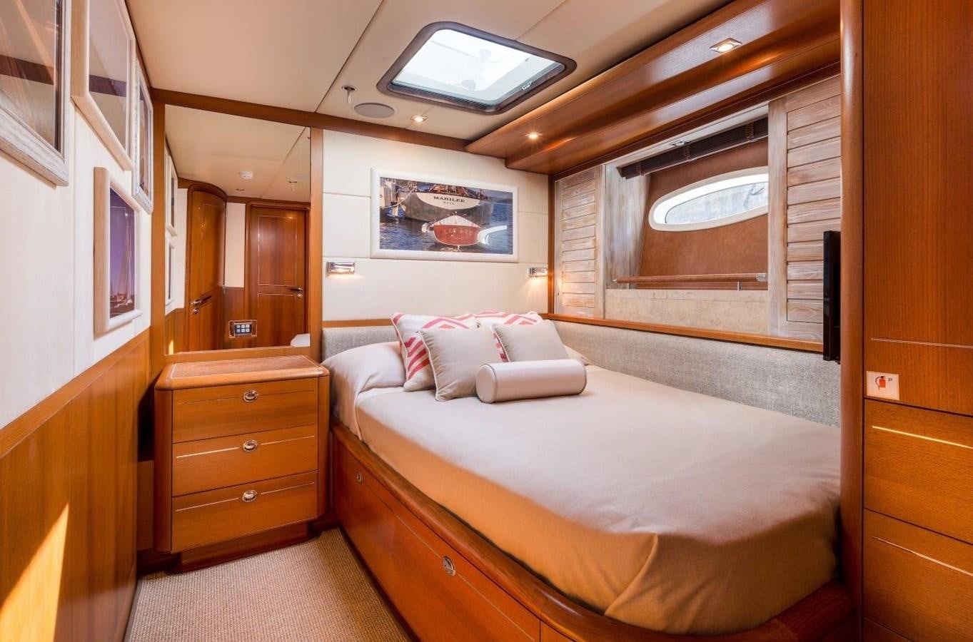 a bedroom with a bed and a dresser aboard DANNESKJOLD Yacht for Sale