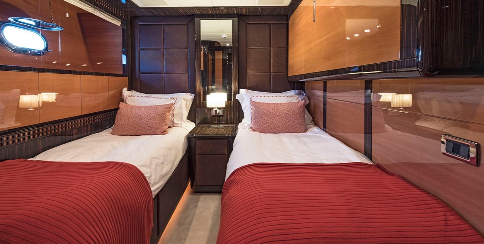 a room with beds and a mirror aboard GLESS Yacht for Sale