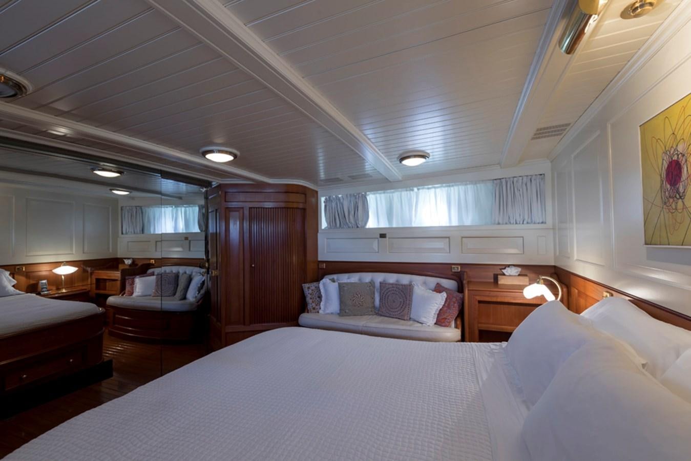 a large bedroom with a bed and a chair aboard LADY MAY OF GLANDORE Yacht for Sale