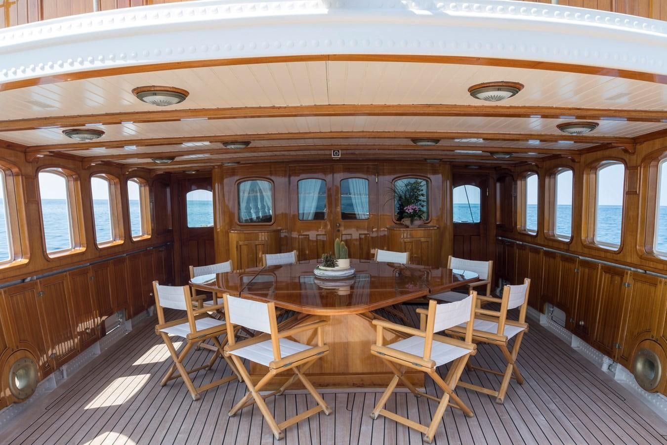 a room with tables and chairs aboard LADY MAY OF GLANDORE Yacht for Sale