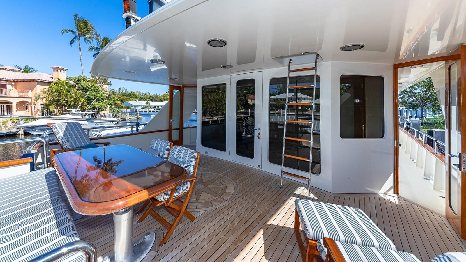 a deck with a table and chairs on it aboard SEAQUEL Yacht for Sale