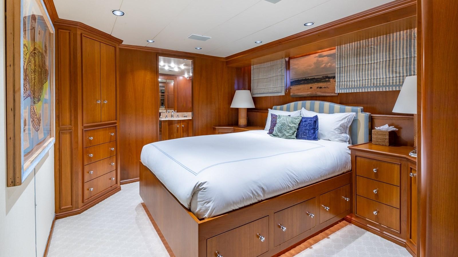 a bedroom with a bed and a dresser aboard SEAQUEL Yacht for Sale