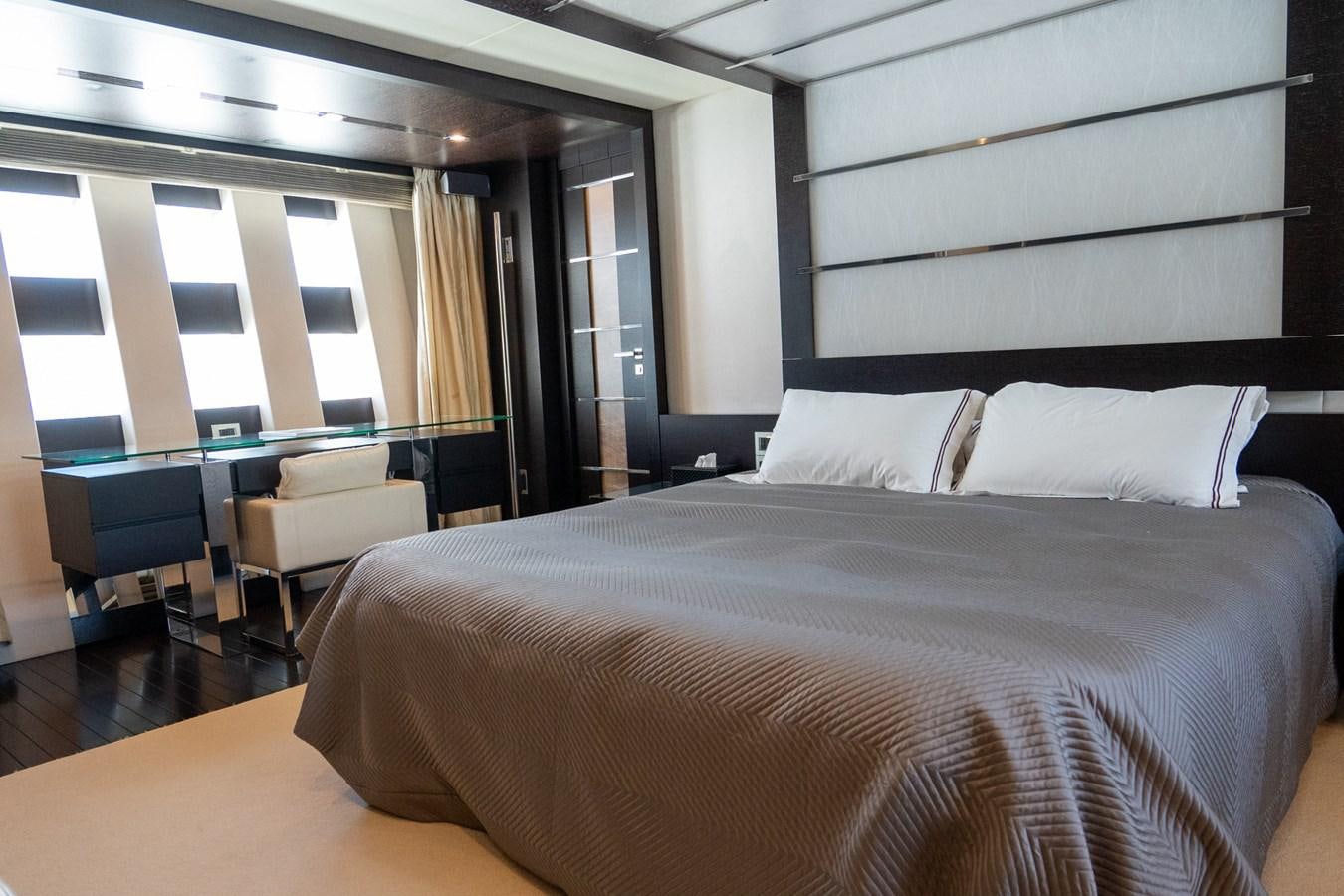 a bed with a black and white bed spread aboard AQUARIUS Yacht for Sale