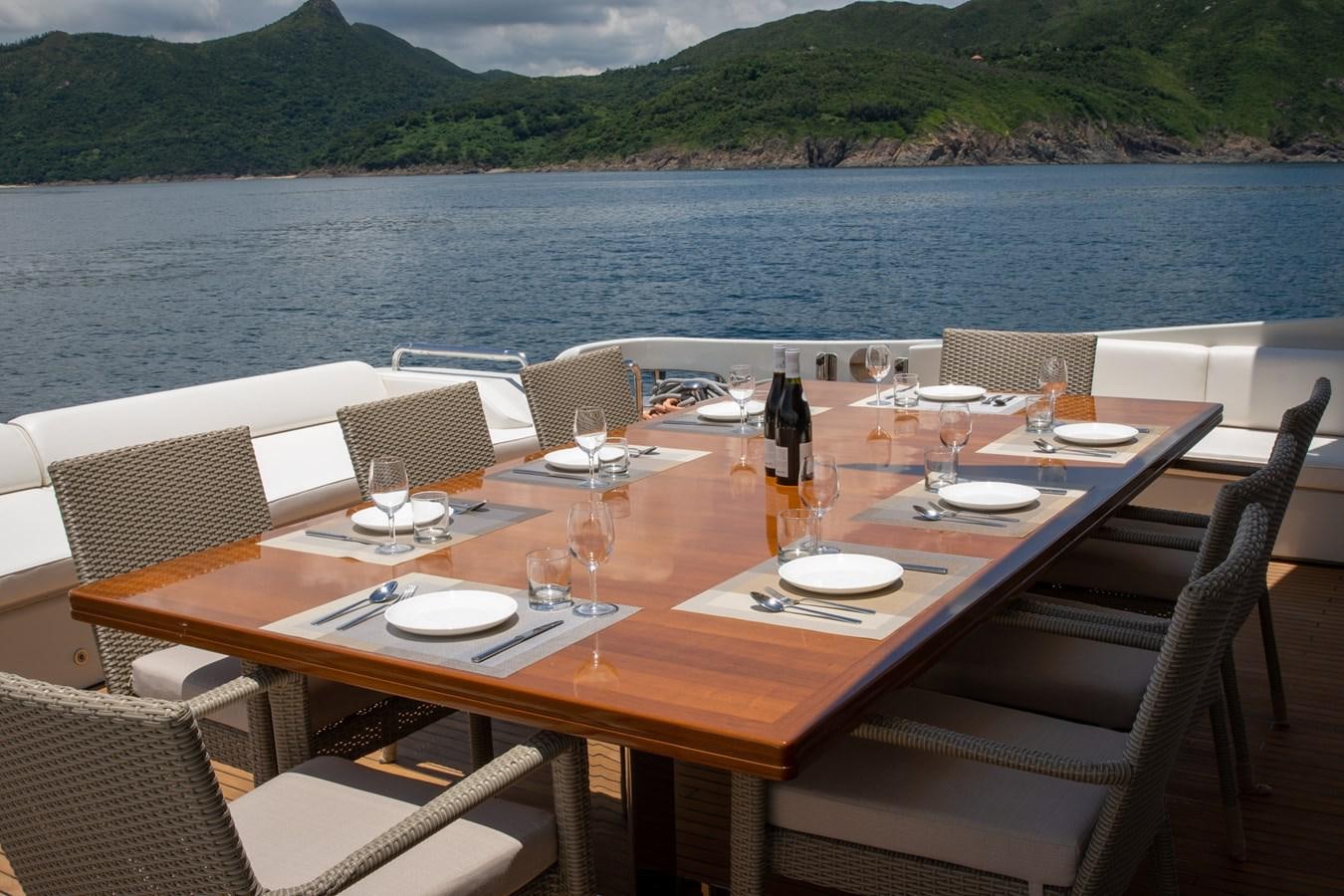 a table set for a meal on a beach aboard AQUARIUS Yacht for Sale