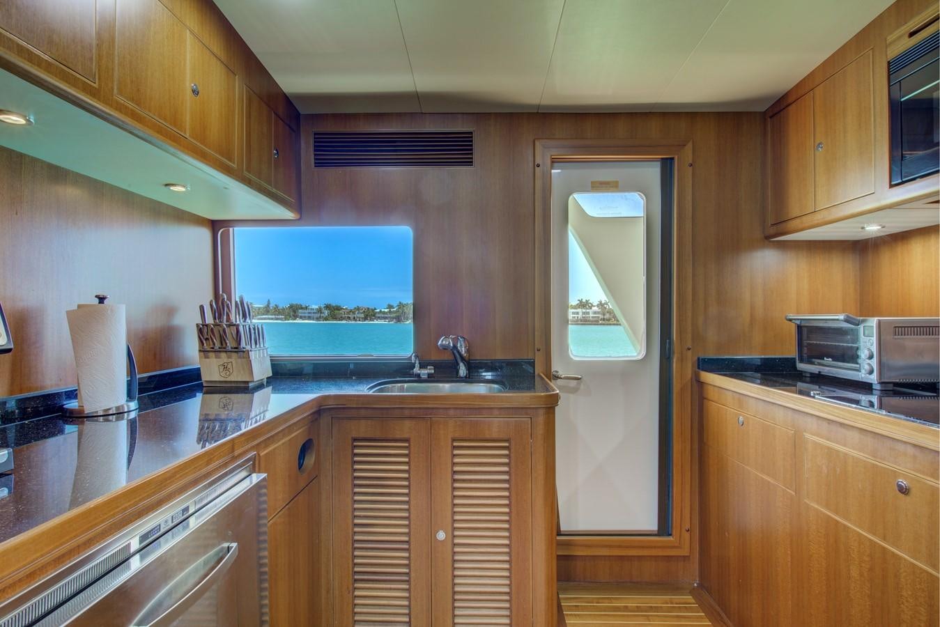 a kitchen with wooden cabinets aboard EXPLORER 97E-CB Yacht for Sale
