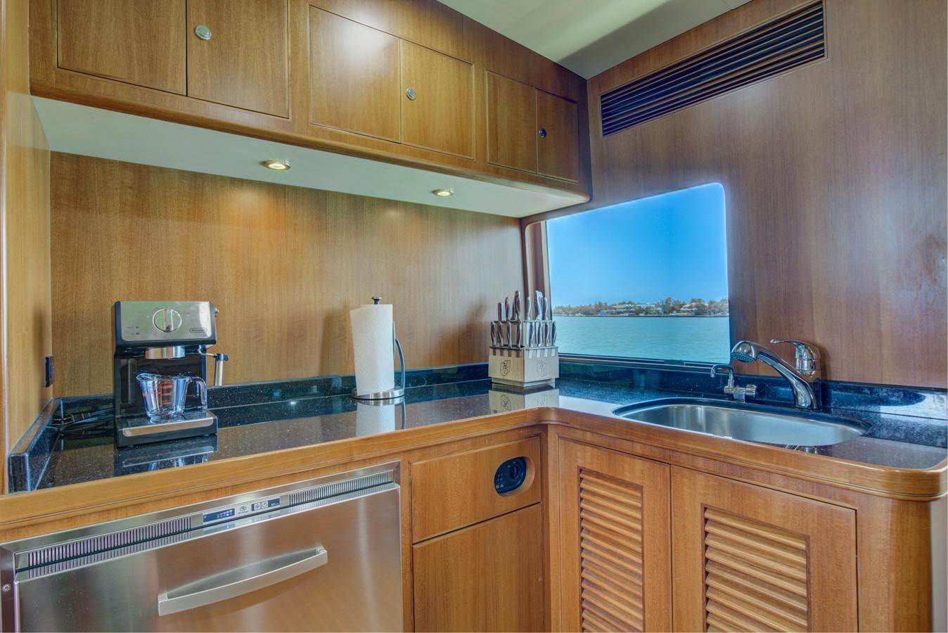 a kitchen with wooden cabinets aboard EXPLORER 97E-CB Yacht for Sale