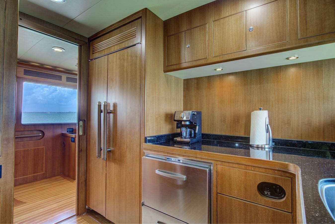 a kitchen with wooden cabinets aboard EXPLORER 97E-CB Yacht for Sale