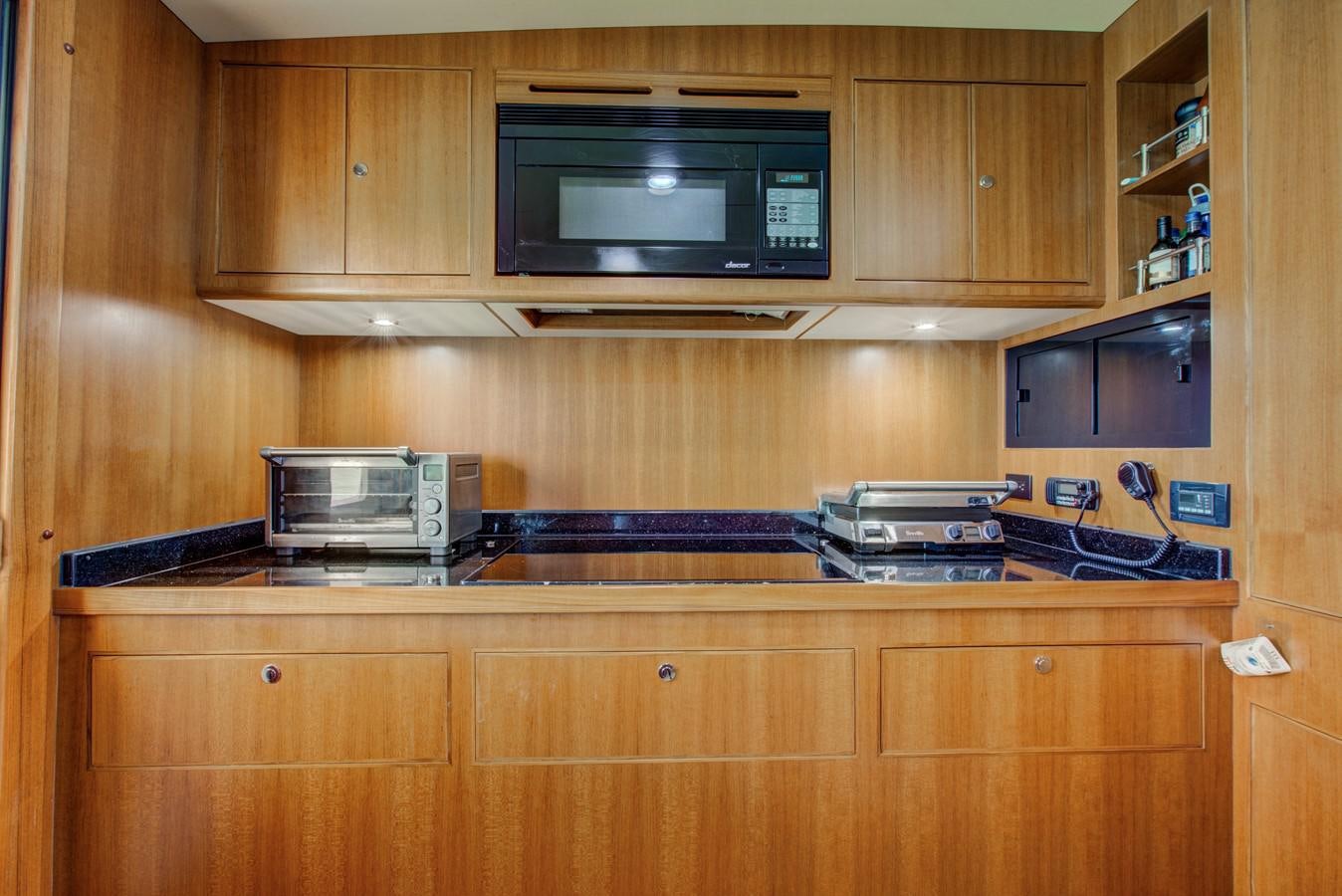 a microwave oven on a wooden cabinet aboard EXPLORER 97E-CB Yacht for Sale
