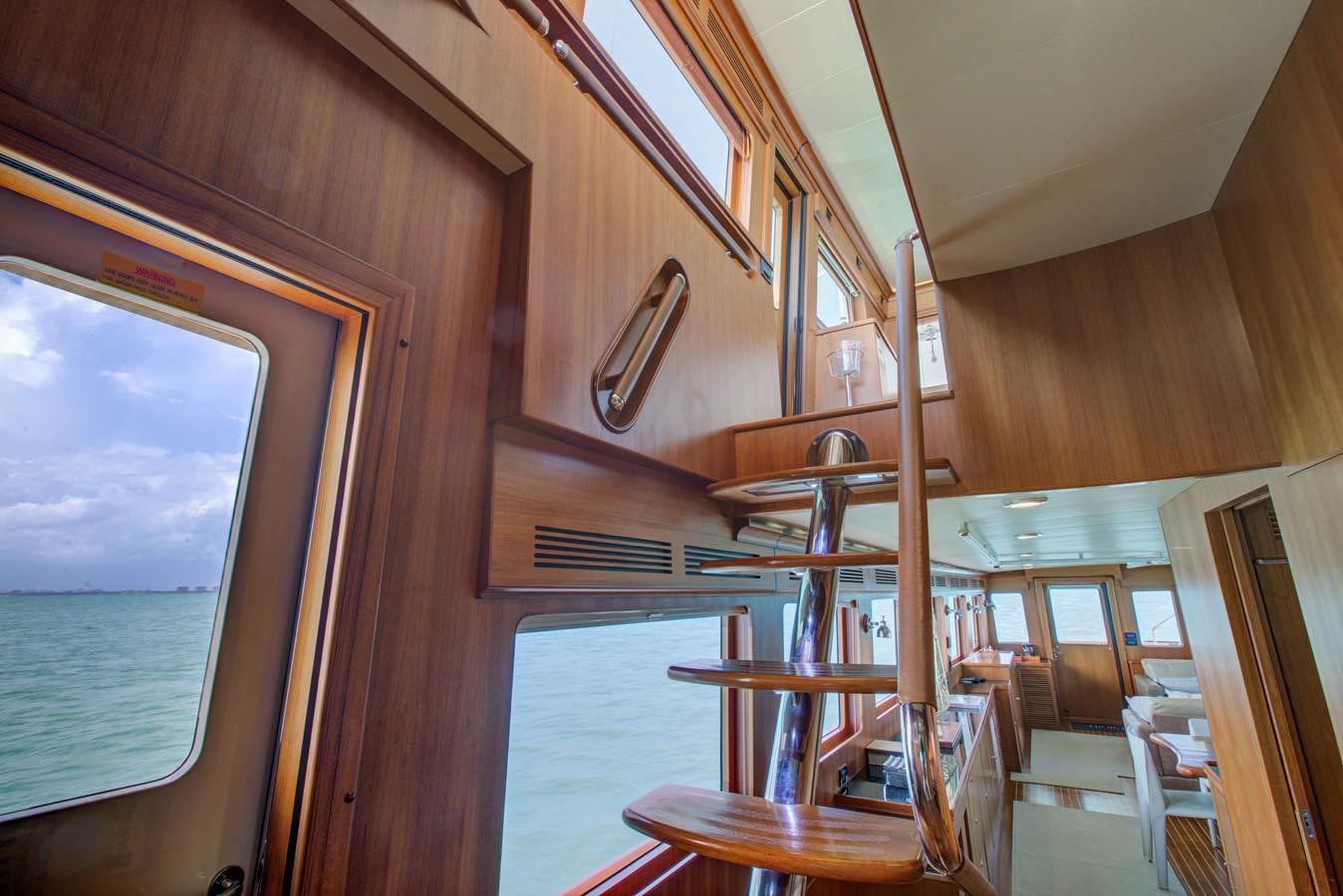 a wooden cabin with a table and chairs aboard EXPLORER 97E-CB Yacht for Sale