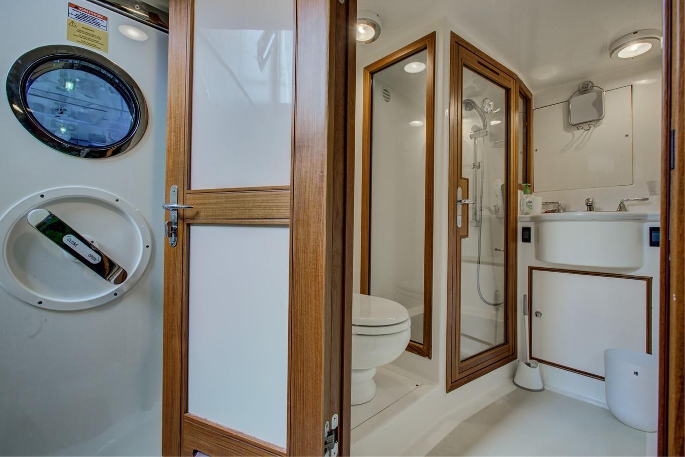 a washroom with a toilet and washer aboard EXPLORER 97E-CB Yacht for Sale