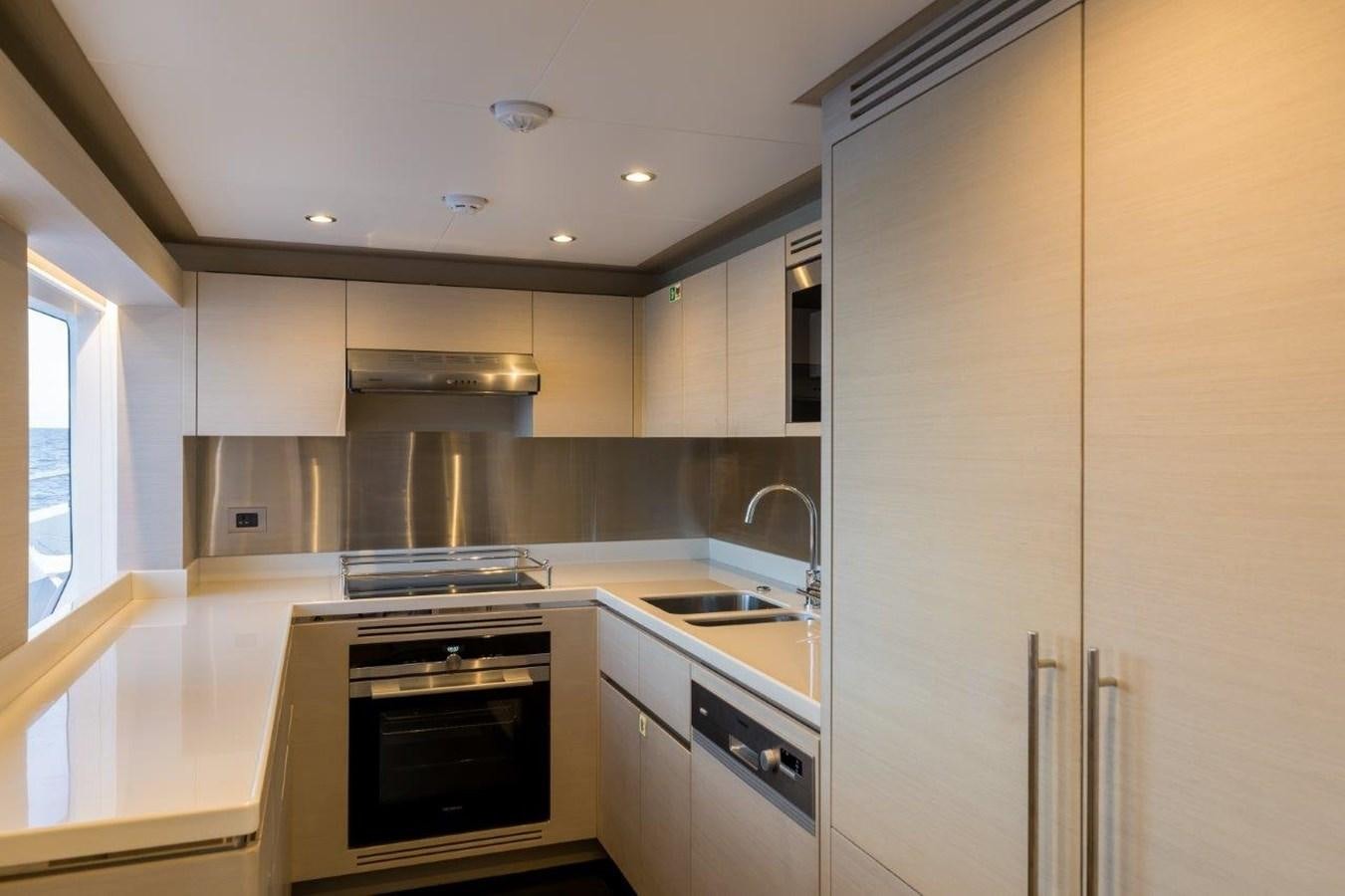 a kitchen with white cabinets aboard JEWEL Yacht for Sale