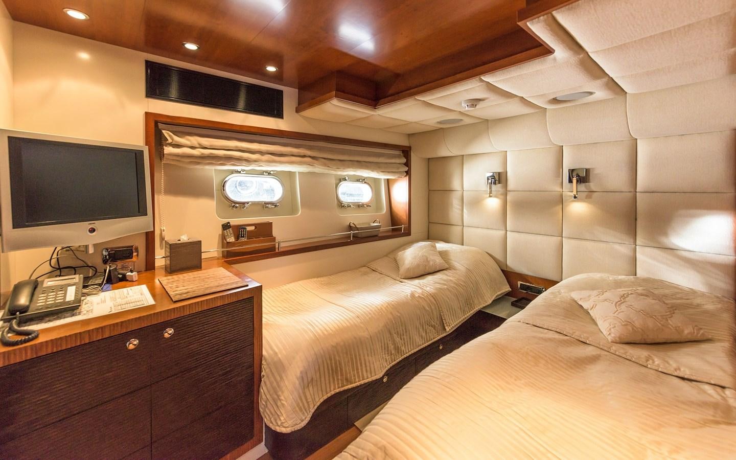 a room with two beds and a tv aboard LITTLE PERLE Yacht for Sale