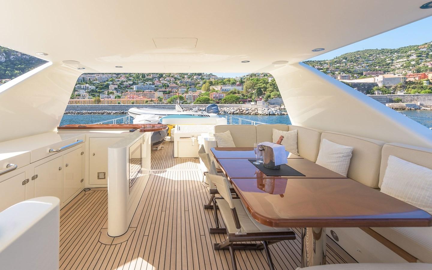 a deck with a table and chairs aboard LITTLE PERLE Yacht for Sale