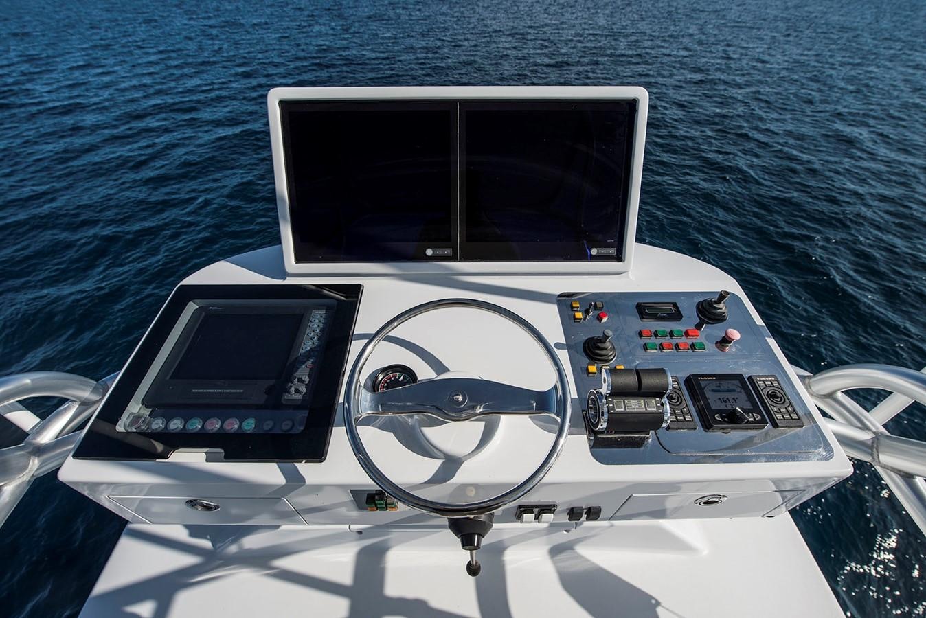 a boat with a steering wheel and dashboard aboard SATU Yacht for Sale