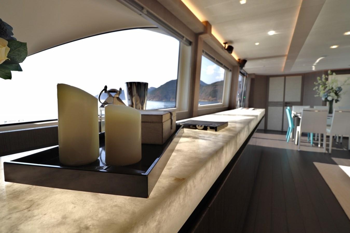 a room with a large window and a table with chairs aboard MONTE CARLO YACHTS 86 Yacht for Sale