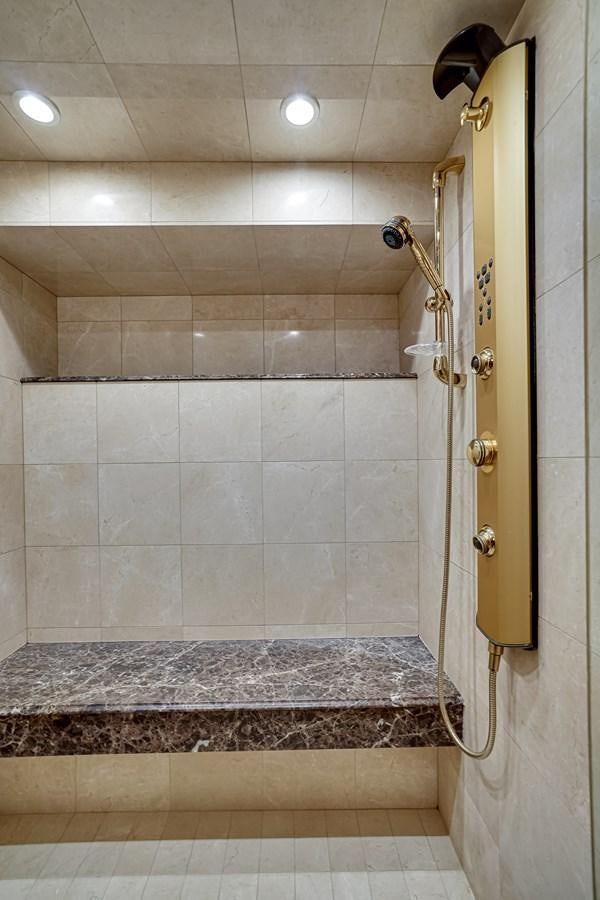 a bathroom with a shower and a marble counter top aboard CHECKERS Yacht for Sale
