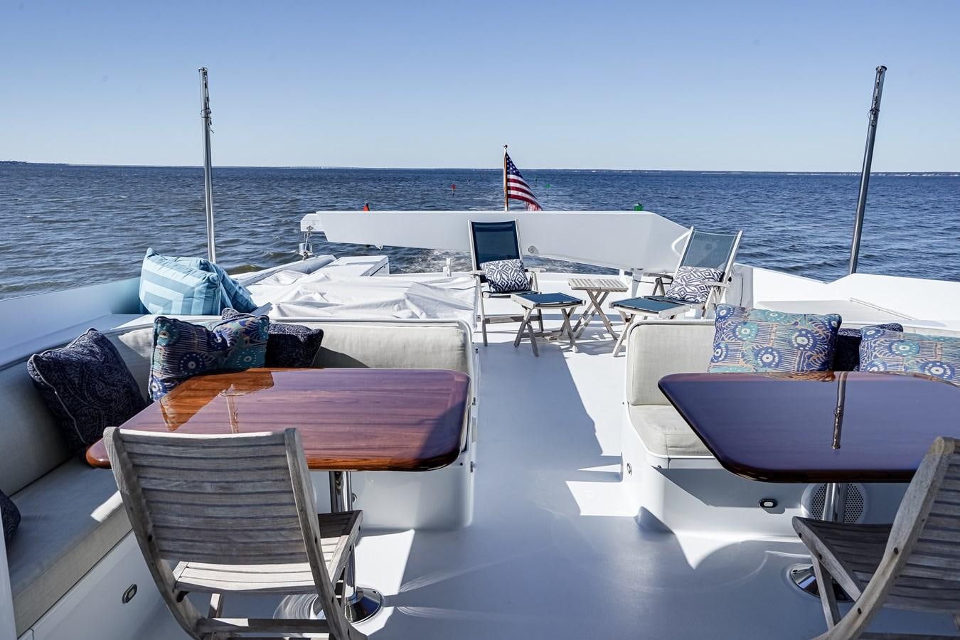 a boat with chairs and tables on the deck aboard CHECKERS Yacht for Sale