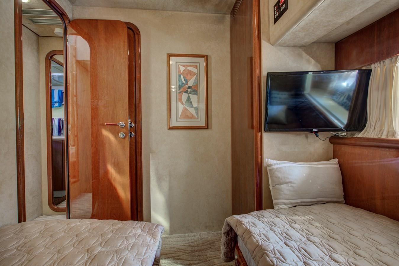 a room with a bed and a television aboard FERRETTI Yacht for Sale