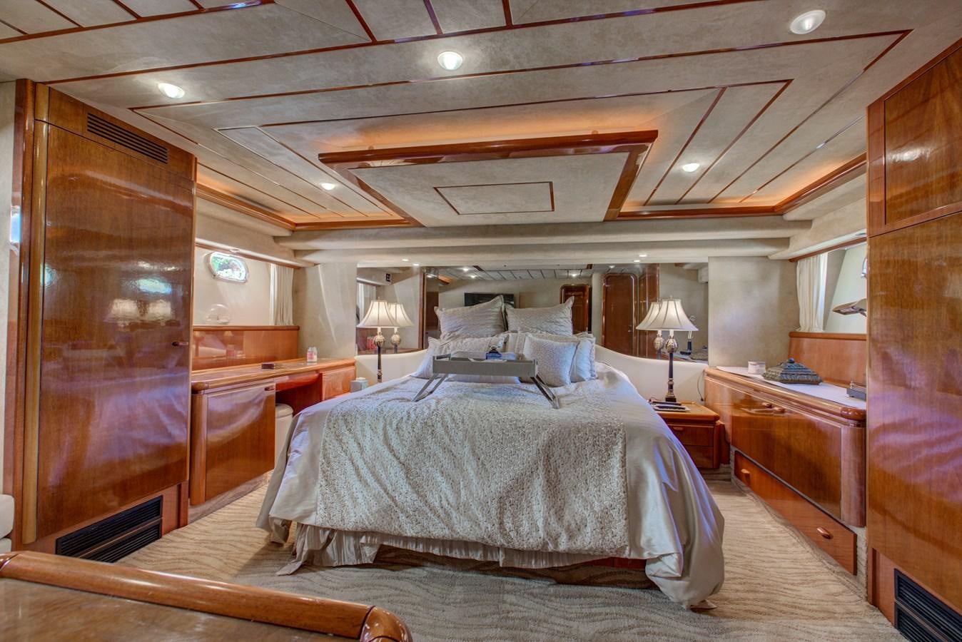 a bedroom with a bed and a wood cabinet aboard FERRETTI Yacht for Sale