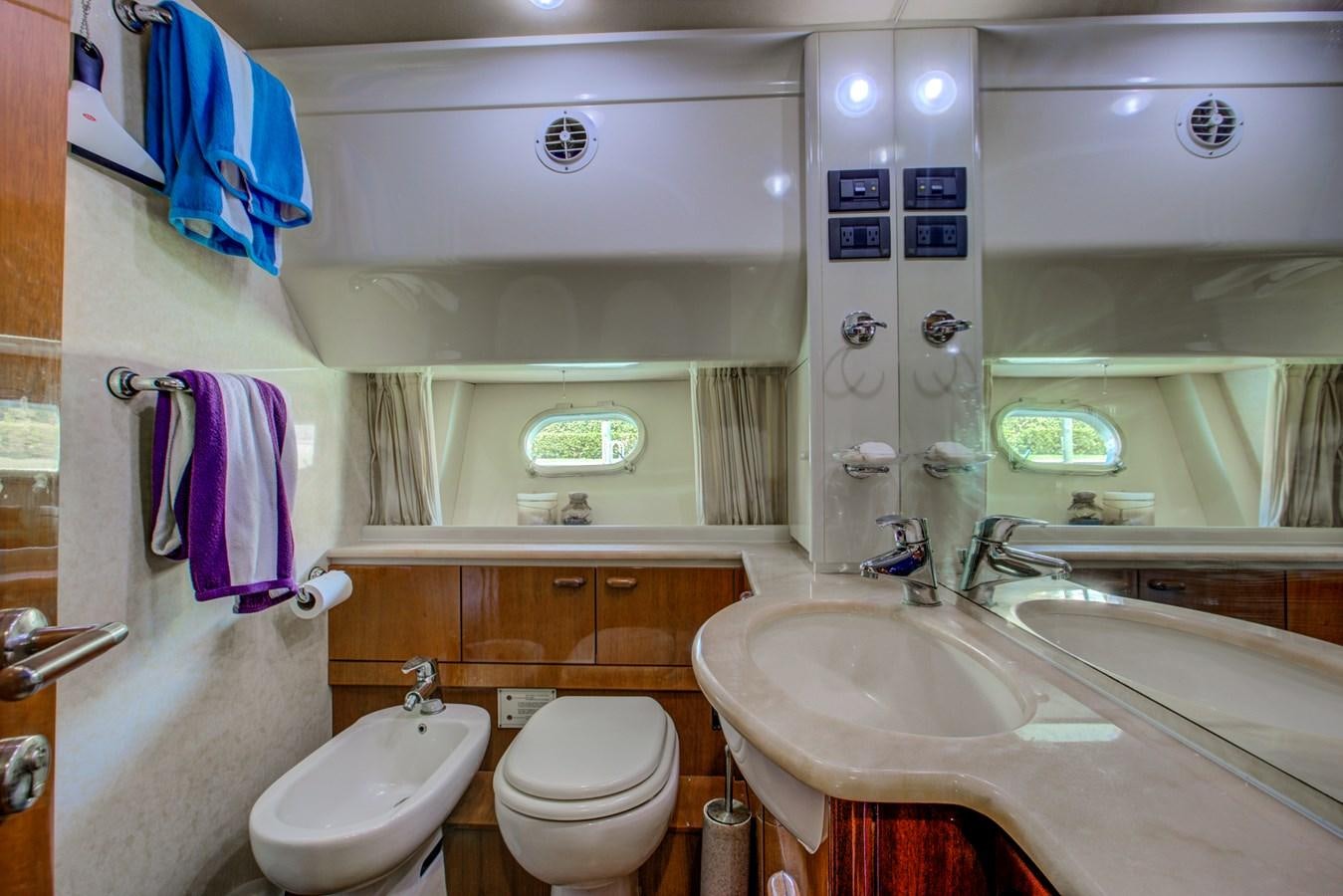 a bathroom with a sink toilet and a mirror aboard FERRETTI Yacht for Sale