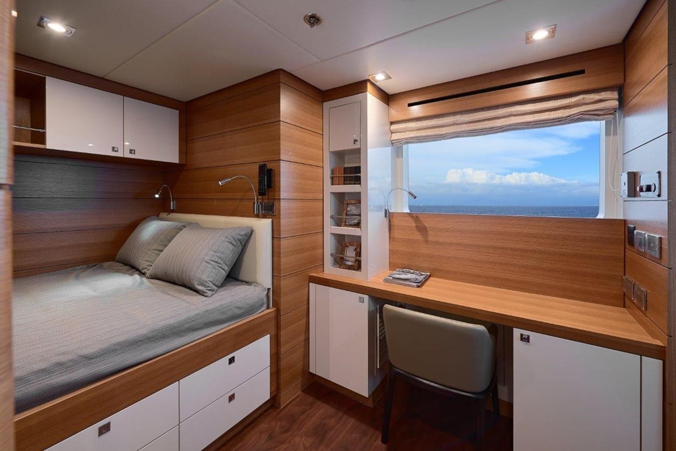 a bedroom with a desk and a bed aboard EP150 Yacht for Sale