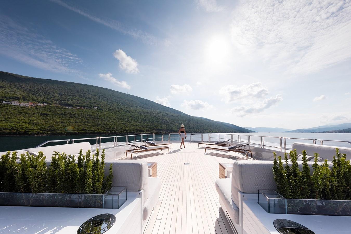 a person standing on a deck overlooking a body of water aboard GAJA Yacht for Sale