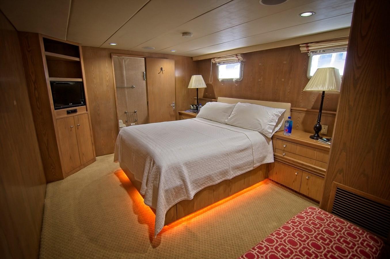 a bedroom with a bed and a lamp aboard VICTORY Yacht for Sale