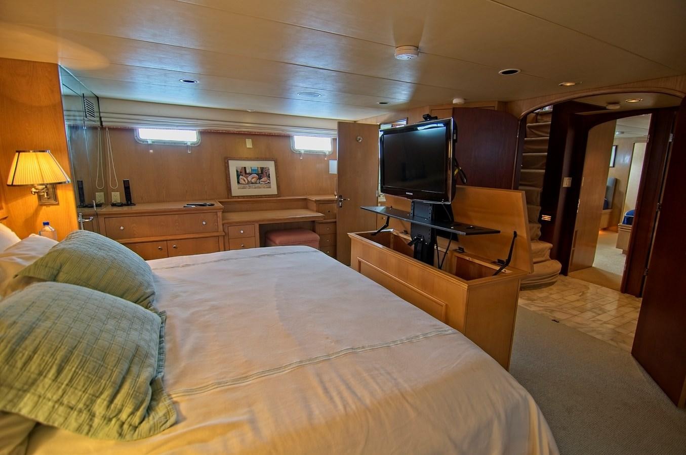 a bedroom with a bed and a tv aboard VICTORY Yacht for Sale