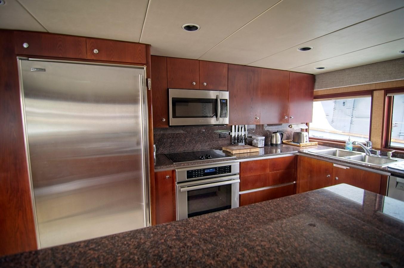 a kitchen with a stainless steel refrigerator aboard VICTORY Yacht for Sale