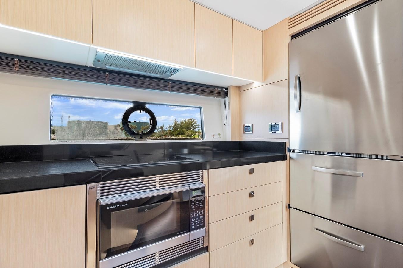 a kitchen with a microwave oven and refrigerator aboard SUNSEEKER PREDATOR Yacht for Sale