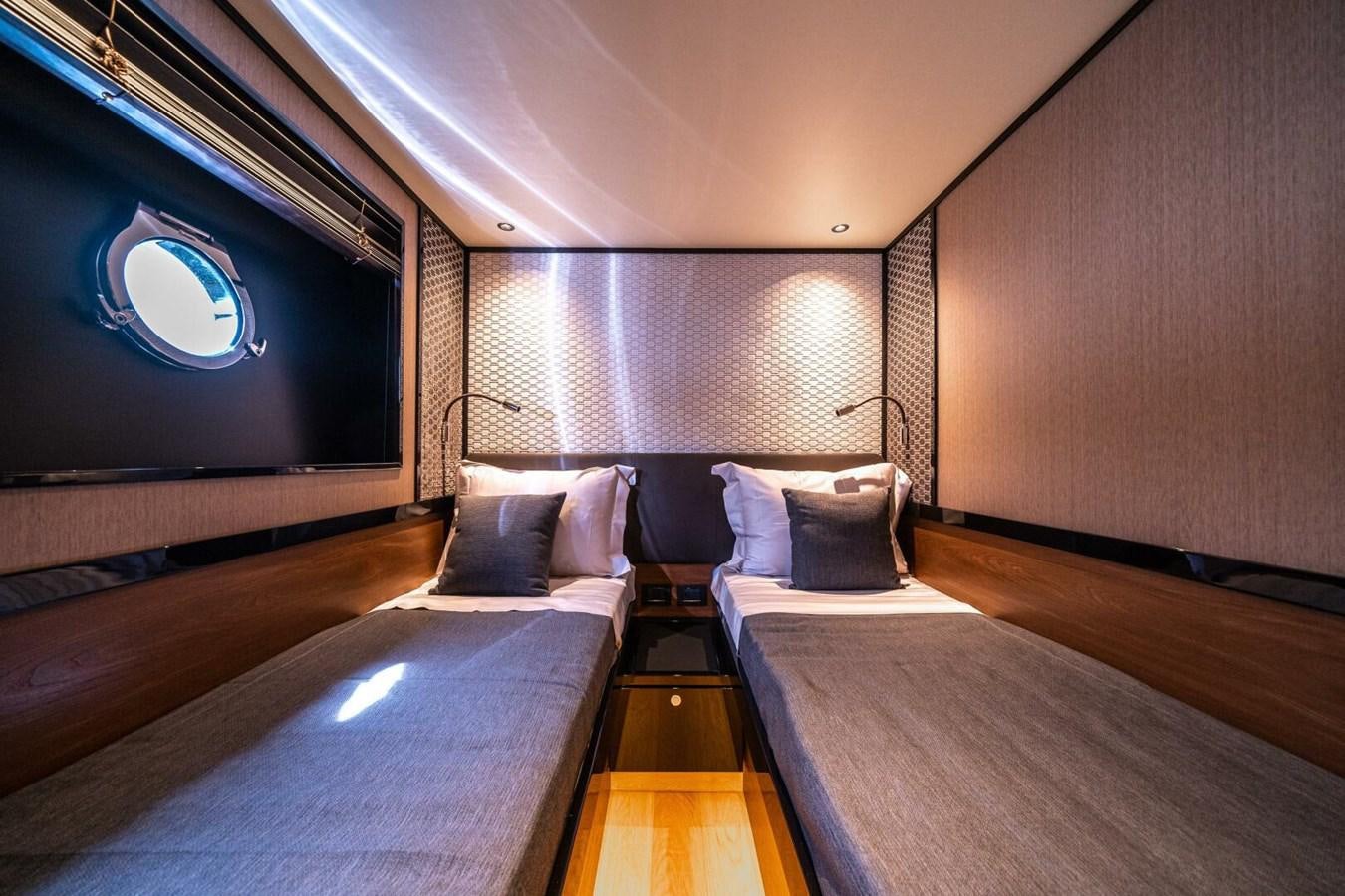a room with a bed and a tv on the wall aboard NAVETTA 68 Yacht for Sale